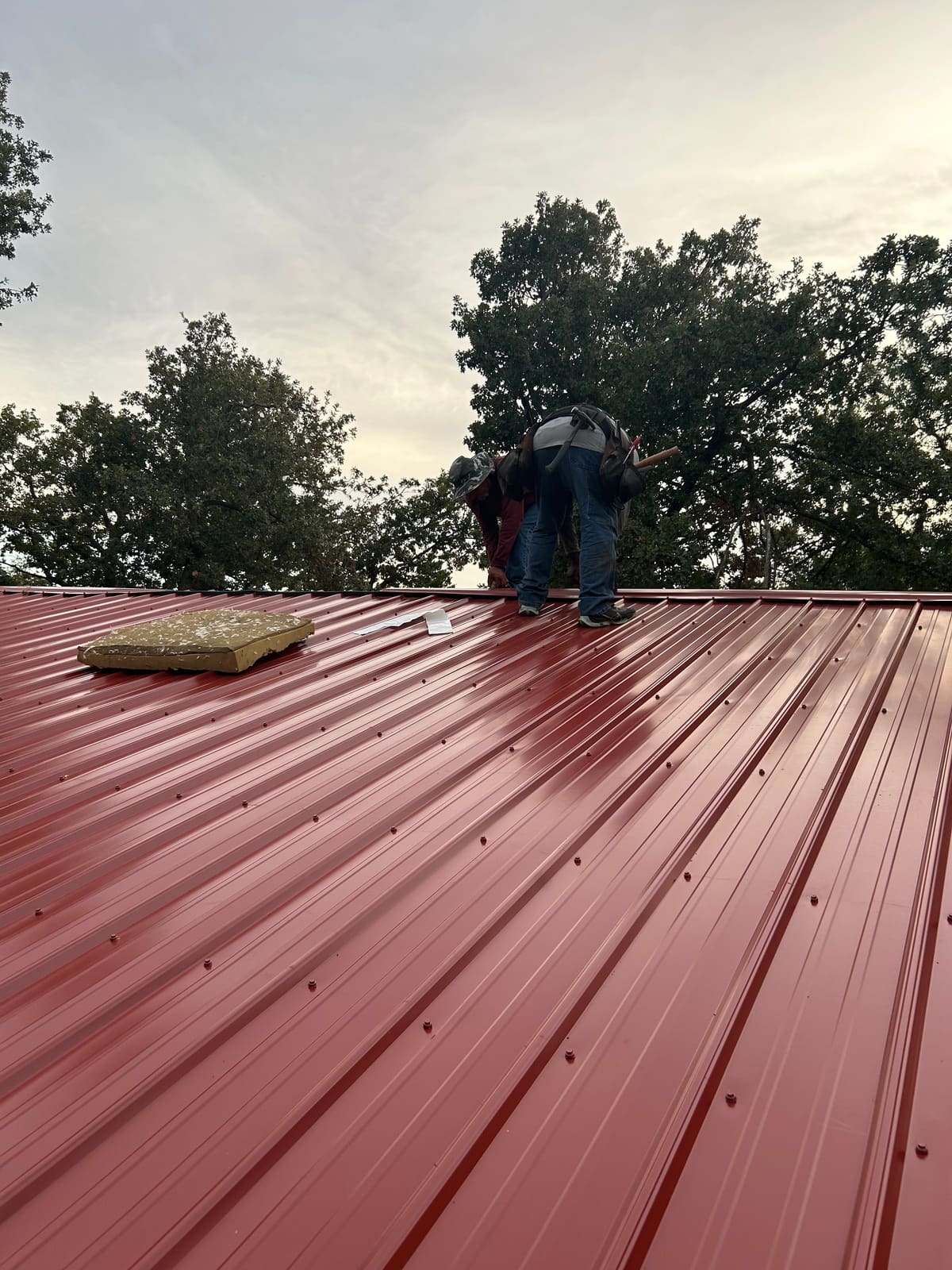 Finishing out a red metal roof out in the country