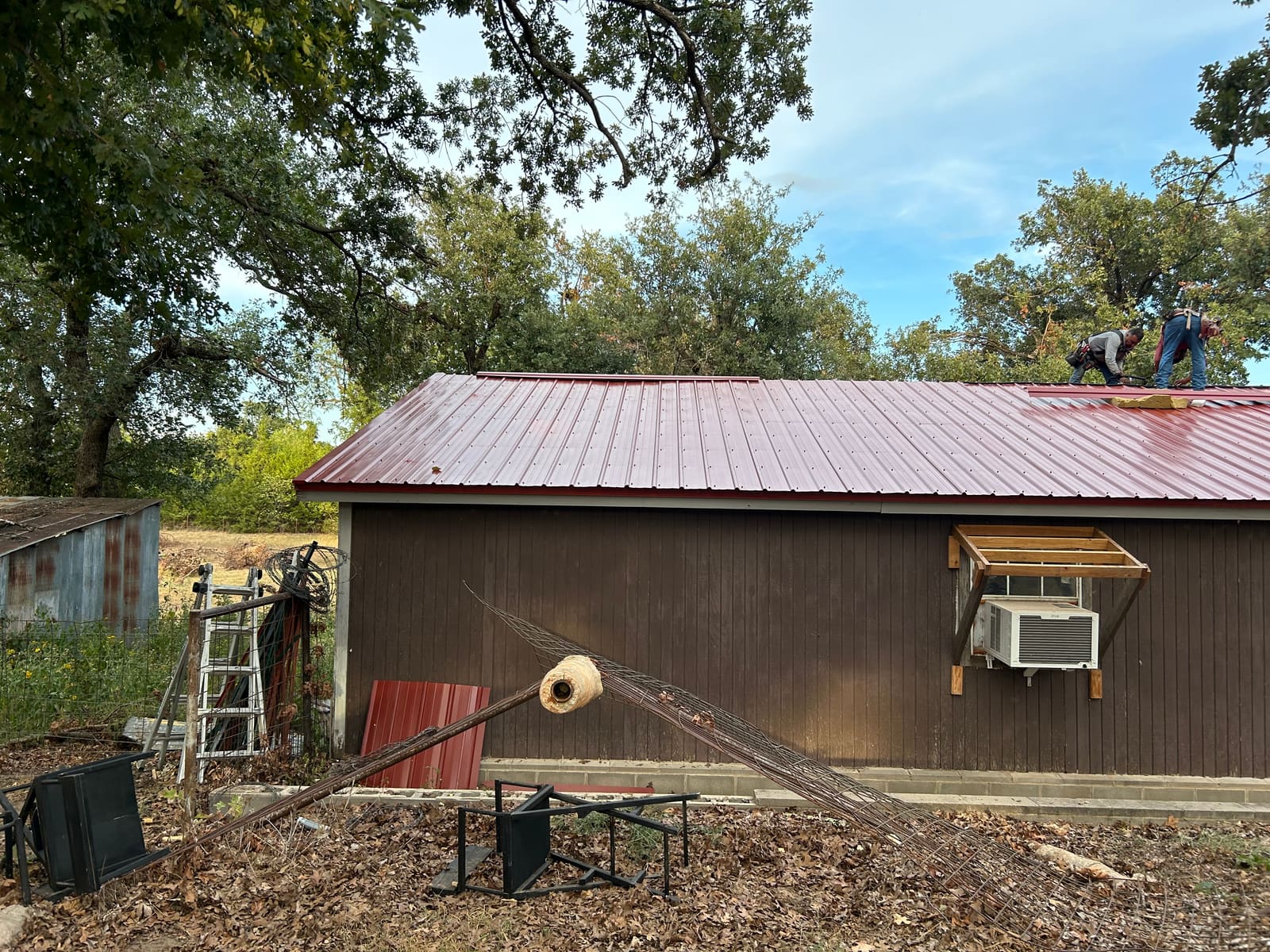Red exposed-fastener metal roof on a rural Oklahoma building